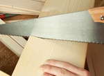 a handyman saws through a piece of wood