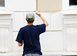 a craftstman paints the exterior of a commercial building